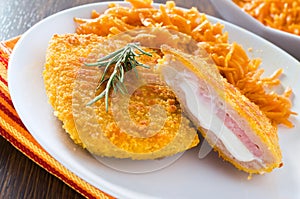 Chicken cordon bleu with grated carrots.