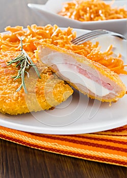 Chicken cordon bleu with grated carrots.