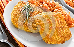 Chicken cordon bleu with grated carrots.