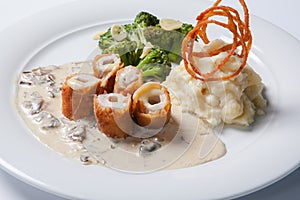 Chicken Cordon bleu on a plate with rustic mashed potatoes.