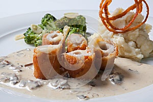 Chicken Cordon bleu on a plate with rustic mashed potatoes.