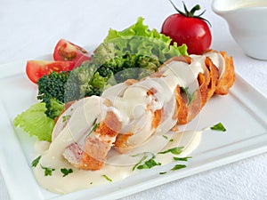 Chicken cordon bleu sliced with parmesan cream sauce