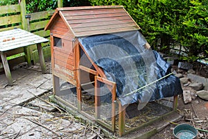 Chicken coup with concrete base and improvised waterproof cover