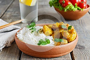 Chicken curry with rice on a wooden surface
