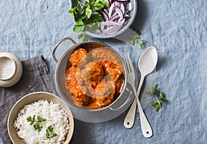 Chicken curry sauce meatballs and rice on a blue background, top view. Indian food. Healthy food