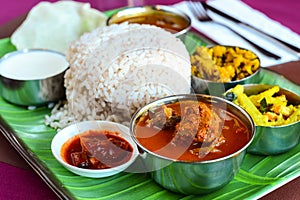 Chicken curry thali served with dry potato and caulifower curry rasam curd and papad