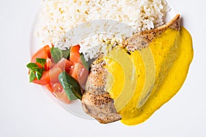 Chicken curry with white rice and vegetables in a white plate close up