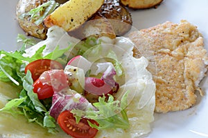 Chicken cutlet, baked potatoes, salad and mozzarella cheese.