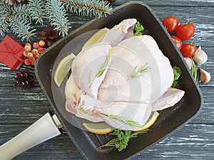 Chicken damp, gift box Christmas tree in a pan food preparation on a white wooden background, tomatoes, lemon