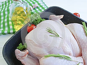 Chicken damp, organic whole ingredient gourmet in a pan kitchen food preparation on a white wooden background, tomatoes, lemon