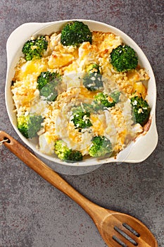 Chicken Divan is a creamy casserole that traditionally made with a chicken, broccoli, cream, cheese close up in the dish. vertical