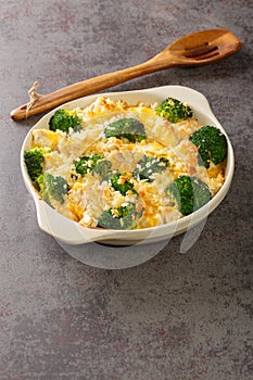 Chicken Divan is a creamy casserole that traditionally made with a chicken, broccoli, cream, cheese close up in the dish. vertical