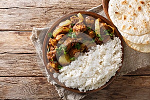 Chicken Do Pyaaza cooked in a variety of spices, yogurt and kasoori methi served with rice and flatbread. Horizontal top view