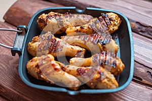 Chicken drumsticks cooked with spices on a grill pan