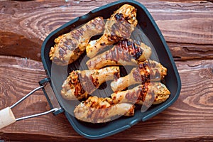Chicken drumsticks cooked with spices on a grill pan