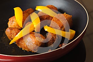 Chicken drumsticks on frying pan.