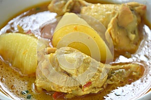 chicken drumsticks massaman curry with slice potato and onion on bowl