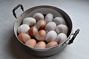 Chicken and duck eggs in steamer basket on the table.