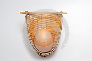 Chicken egg in bamboo weave basket on white