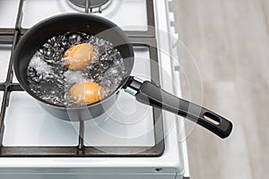 chicken egg with broken shell in boiling water