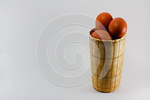 chicken egg in a small woven bamboo basket