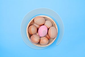 Chicken egg in wood bowl on blue background with preserved egg