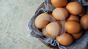 Chicken eggs in a basket on a gray background