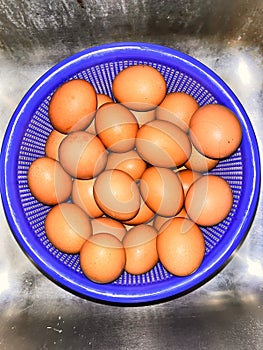 chicken eggs in a blue basket in the kitchen