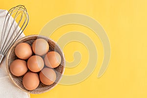 Chicken eggs, brown eggs, broken egg in carton box on yellow background. Top view natural eggs in carton box product concept