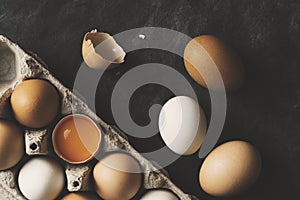 Chicken eggs in carton on black rustic background