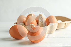 Chicken eggs in carton box on wooden table