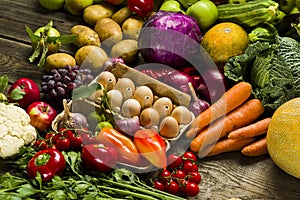 chicken eggs in the center with fresh vegetables on a table