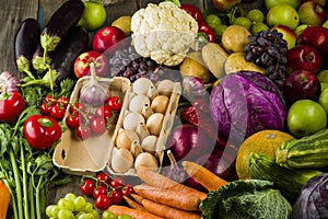 chicken eggs in the center with fresh vegetables on a table