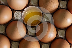 Chicken eggs lie in a tray on the kitchen surface with a broken yellow yolk. Buying products and goods in the store.