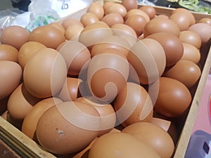 Chicken eggs are placed in a lot of wooden crates.