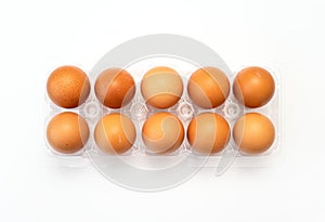 Chicken eggs in plastic package on white.