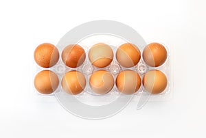 Chicken eggs in plastic package on white.