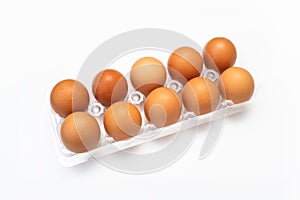 Chicken eggs in plastic package on white.