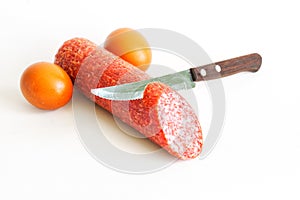 Chicken eggs, salami and a sharp knife on a white background. Concept and metaphor for male circumcision in Judaism. Genital