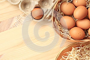 Chicken eggs in a wicker basket and cardboard box, top view