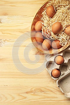 Chicken eggs in a wicker basket and cardboard box, top view