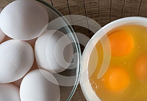 Chicken eggs, Yolk in a ceramic dish on a wooden background, top view