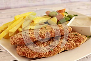 CHICKEN ESCALOPE with French Fries, Salad and Dip served in dish isolated on table side view of arabic fastfood