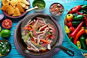 Chicken fajitas in a pan chili and sides Mexican