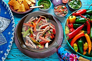 Chicken fajitas in a pan chili and sides Mexican