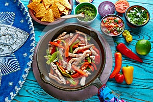 Chicken fajitas in a pan chili and sides Mexican