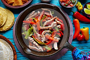 Chicken fajitas in a pan chili and sides Mexican