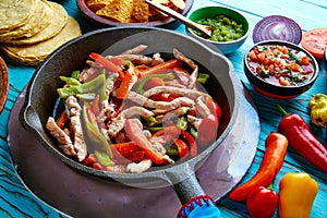 Chicken fajitas in a pan chili and sides Mexican photo
