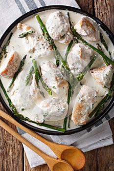 Chicken fillet with asparagus in a creamy sauce close-up on a pl