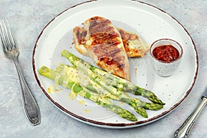 Chicken fillet cooked on a grill and garnish of asparagus